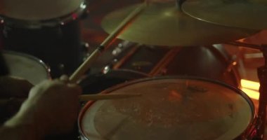 Bir rock müzisyeni bir konserde davul çalar. Müzisyenlerin yakın çekim elleri davullara vurur. Yüksek kalite 4k görüntü