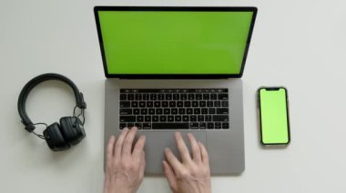 Top View of Green Screen Laptop, Smartphone ve kulaklıklar, merkez ofisteki çalışma masasındaki Hdd disk. Yüksek kalite 4k görüntü