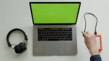 Top View of Green Screen Laptop, Smartphone ve kulaklıklar, merkez ofisteki çalışma masasındaki Hdd disk. Yüksek kalite 4k görüntü