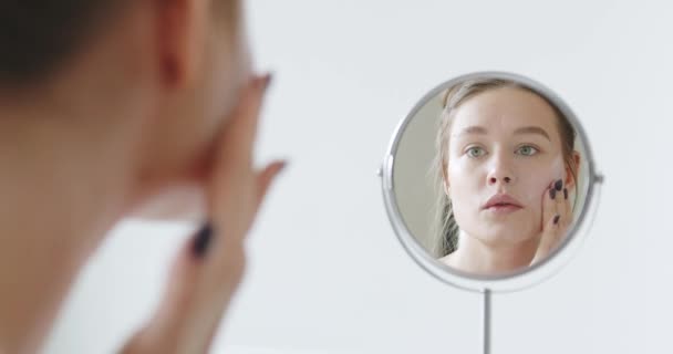 Młoda Kobieta Dba Skórę Twarzy Wykonuję Zabiegi Kosmetyczne Wcierając Krem — Wideo stockowe