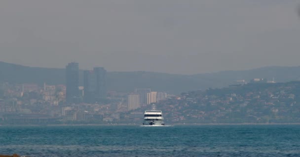 旅客船フェリーは 都市の近代的な大都市を背景に海に帆 イスタンブールのトルコのボスポラス海峡での船 都市性 バランス 高品質4K — ストック動画