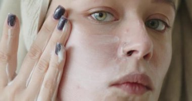 Kadın temizlik yüzünü organik köpüklü sabun temizleyicisiyle yıkıyor. Kız cildini temizliyor, masaj hareketleri yapıyor. Güzellik prosedürü, spa, sağlık ve sağlıklı cilt bakımı konsepti. Yüksek kalite