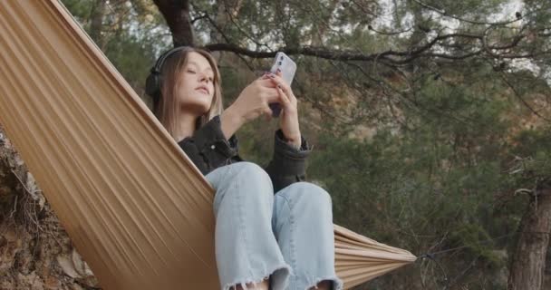 Girl Headphones Listens Music Takes Selfie Phone Hammock Picnic City — Stock Video