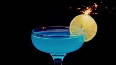 Barbekü kokteyli. Barbekü çekirdeği. Profesyonel barmen mavi bir kokteyli buzla süslüyor. Barmen, çözülmüş arka plan üzerine kokteyller hazırlıyor ve bir kokteyl veriyor. Barmen renkli hazırlanıyor.