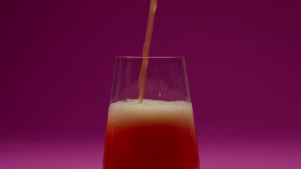 オレンジジュースをガラスに注ぐ超スローモーション ピンクの背景に置かれている 高速シネマカメラ 1000 Fpsで撮影されました 高品質の4K映像 — ストック動画