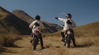 İki dağ motosikletçisi kayalık bir dağ yolunda saldırganca başlıyorlar. Dağlardaki dağ bisikletleri bir dağ yolunda gidiyor. Gezginler ve maceracılar. Olağanüstü motosiklet sürüşü. Eski