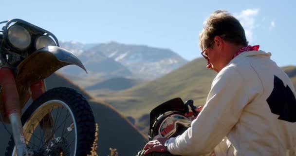 Meio Montanhas Deslumbrantes Céu Motociclista Montanha Limpa Seu Capacete Óculos — Vídeo de Stock