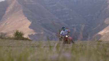 Görkemli dağların arka planında, bir adam eskimiş dayanıklı motosikletine binerek heyecan verici bir yolculuğa çıkıyor, açık bir alanda dizginlenemez bir özgürlük ruhuyla yırtınıyor. Kükreme