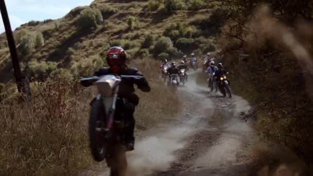 冒険的なオートバイの船団は 彼らのヴィンテージエンドゥロバイク上のほこりと険しい山のトレイルを横断して 爽快な旅に出発します オフロード遠征が彼らを導く — ストック動画
