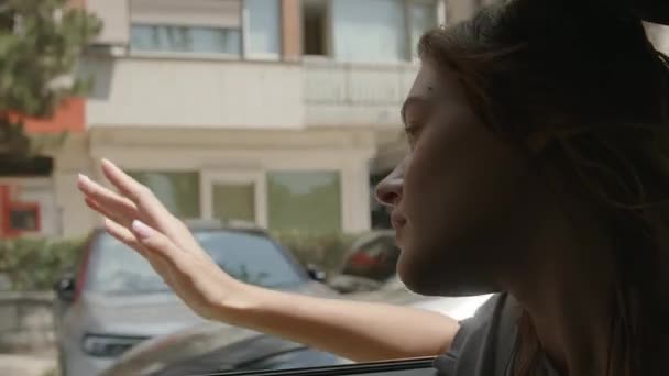 この刺激的なビデオクリップで都市探検の魔法を体験してください ミディアムクローズアップで撮影 シーンは車の窓から漏れている若い女性と展開します 彼女の指がに到達 — ストック動画