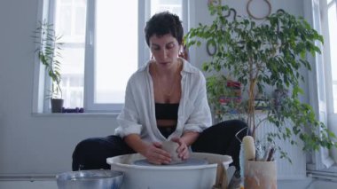 Genç ve yetenekli bir seramik sanatçısı, kilin kalıbını tutkulu bir şekilde çömlek çarkının üzerindeki kilden bir vazoya dönüştürüyor. Elleri, çamura batmış, ustalıkla sanatsal görüşünü getiriyor.