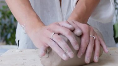 Kadınların elleri, çömlekçi çarkındaki iş için dar killeri yoğurur. Bir kadının el emeği çok çalışmaktır. Kadın sanatçılar yaratıyor, başarıya ulaşıyorlar, feminizm iş başında. Yakın çekim ağır çekim 120