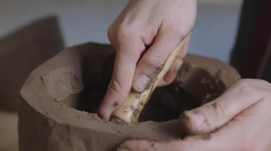 Sanatçının derin etkisini, kısa saçlı bir zanaatkârın kilin yaratıcı bir ifade aracına dönüşmesini yakından izleyerek yaşayın. Bu yakın planda yapılan keşifte, sanatın