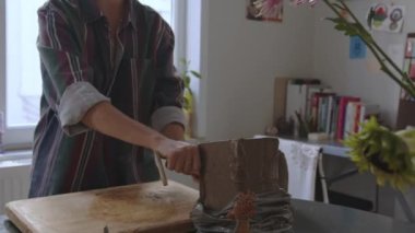 Sanatçının derin etkisini, kısa saçlı bir zanaatkârın kilin yaratıcı bir ifade aracına dönüşmesini yakından izleyerek yaşayın. Bu yakın planda yapılan keşifte, sanatın