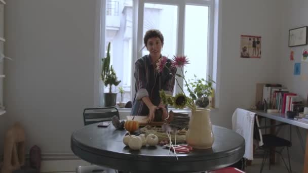 女陶瓷艺术家 身穿男式衬衫 揉搓生粘土制成花瓶 在她工作室的桌子上有陶瓷和粘土的加工工具 她是个独立人士 — 图库视频影像