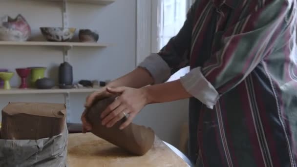 女陶瓷艺术家 身穿男式衬衫 揉搓生粘土制成花瓶 在她工作室的桌子上有陶瓷和粘土的加工工具 她是个独立人士 — 图库视频影像