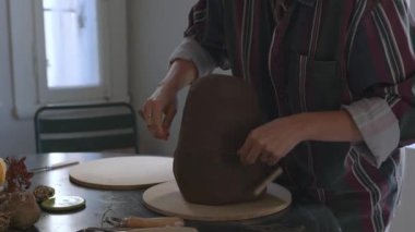 Sanatçının derin etkisini, kısa saçlı bir zanaatkârın kilin yaratıcı bir ifade aracına dönüşmesini yakından izleyerek yaşayın. Bu yakın planda yapılan keşifte, sanatın