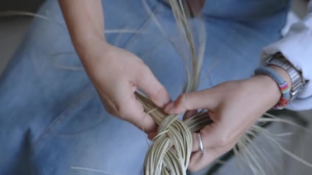 女の子は乾いた草から編み物を編みます 針仕事をする手のクローズアップ 手作業 中小企業 そして家族との調和 高品質の4K映像 — ストック動画