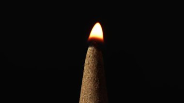 Yakın çekim sükunetinde, zaman bir ateş piramit tütsüsünün tepesini nazikçe öperken ve ipeksi bir duman yumağı yükselirken, sessiz bir barış, meditasyon öyküsü ve