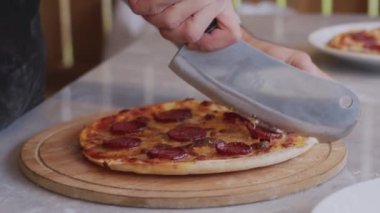 Önlüklü bir adam odun ateşindeki pizza fırınına çiğ pizza koyuyor. Açık ateşte yemek pişirmek. Doğal yiyecekler. Napoli pizzası fırında. Pizzanın yüzeyinde ufalanmış peynir. - Evet. Yüksek