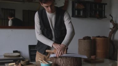 Duyusal bir yolculuğa çıkın. Yetenekli bir zanaatkar, büyüleyici bir videoda zamanın özünü nazikçe yakalar. Bir adam titizlikle, kâğıt üzerinde yüzüklerin taklidini yapar.