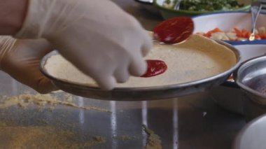 Mükemmel mutfak dünyasına dalın. Şefin eldivenleriyle süslenmiş yetenekli eller gibi. Titizlikle nefis bir pizza pişirin. Bu büyüleyici video pizza yapma sanatını gözler önüne seriyor.