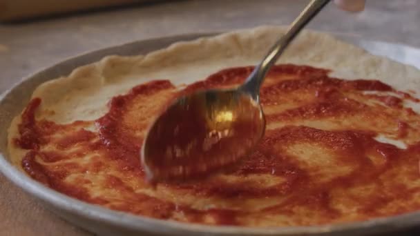 Mężczyzna Fartuchu Rozsypuje Pastę Pomidorową Podstawie Ciasta Pizzowego Stole Posypanym — Wideo stockowe