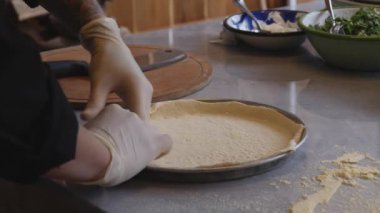 Mükemmel mutfak dünyasına dalın. Şefin eldivenleriyle süslenmiş yetenekli eller gibi. Titizlikle nefis bir pizza pişirin. Bu büyüleyici video pizza yapma sanatını gözler önüne seriyor.