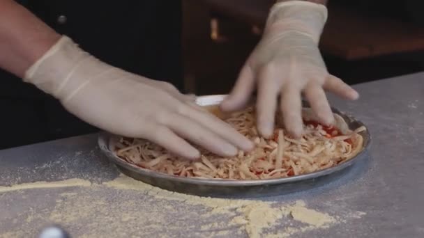 シェフの手袋に飾られた熟練した手のように 料理の卓越性の世界に身を浸してください おいしいピザを細かく作ります この魅惑的なビデオは ピザ作りのアーティストリーを展開し どこで — ストック動画