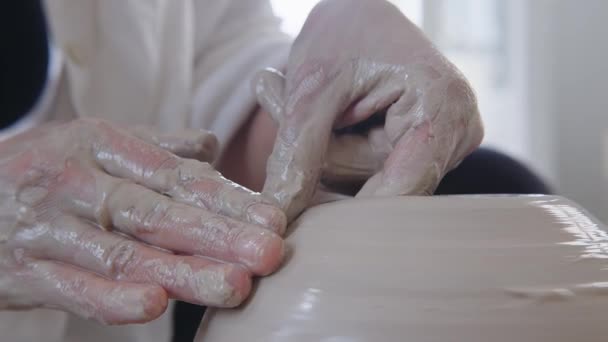 このセレンフレームでは アーティストの手が陶器の車輪に濡れた粘土を複雑に形作っています 手はスリップの薄い層でコーティングされ 作成者の間の触覚関係を強調します — ストック動画