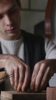 Bağımsız bir LGBT seramik sanatçısı kil şekillerini yetenekli ellerle şekillendirir, dikey 4K 'lık çekimle zanaatın samimiyetini vurgular. Odaklanmış ve yaratıcı, sanatçı rahat bir stüdyoda çalışıyor.