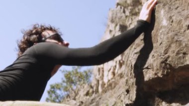 Sinematik bir çekim. Bir adam uçuruma tırmanıyor. Yumuşak odaklı, eski moda film efekti. Profesyonel kaya tırmanıcısı. İş büyümesi, finansal başarılar ve kalkınma kavramı. Motivasyon. Yüksek kalite