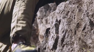 Bu 6K videosunda, tırmanışının bir sonraki aşaması için hazırlanan bir kaya tırmanışçısının odaklanmış ifadesi ve üst gövdesinin detaylı bir portresi yer alıyor. Tırmanışçıların yüzü kısmen görülebilir, gölgeli...