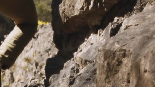 一名登山者 在这个电影慢动作视频中 在陡峭的岩石表面上行走 动作非常小心 广角镜头捕捉了广阔的环境和攀登者与崎岖的地形的相互作用 — 图库视频影像