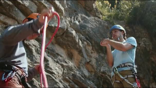 Pair Climbers Check Equipment Rugged Cliff Backdrop Attentive Helmets Harnesses — Stock Video