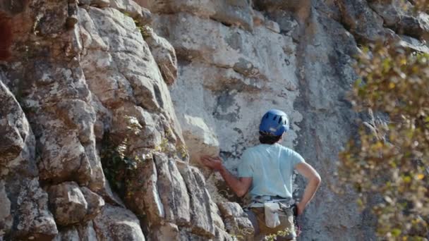 意図的に挑戦的な石灰岩の崖をナビゲートする動きの岩のクライマーは この映画 Prores のキャプチャの焦点です クライマーの青いヘルメットは 彼らが次を評価するように識別可能である — ストック動画