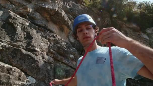 Альпинист Синем Шлеме Тщательным Вниманием Осматривает Красную Веревку Позади Ждет — стоковое видео
