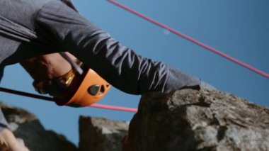 Dağcı kadın, dağ teçhizatıyla dik bir uçuruma tırmanıyor. Kask takmış bir kaya tırmanıcısı ve tırmanma halatlarıyla kaya tırmanışı yapıyor. Kadınların gücü işte. Sinematik bir çekim. Başarı fikri ve...