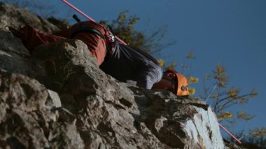 Dağcı kadın, dağ teçhizatıyla dik bir uçuruma tırmanıyor. Kask takmış bir kaya tırmanıcısı ve tırmanma halatlarıyla kaya tırmanışı yapıyor. Kadınların gücü işte. Sinematik bir çekim. Başarı fikri ve...