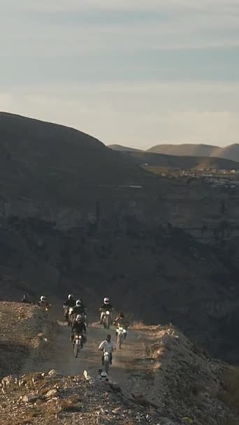 Vertical Frame Captures Group Motorcyclists Riding Formation Narrow Dirt Path — Vídeo de stock