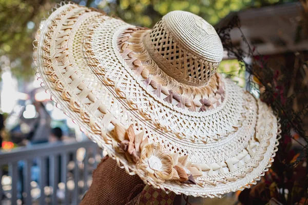Large beige summer straw hat. Top view of a round straw hat. Woman with a large wide-brimmed hat. Street photo, selective focus, nobody