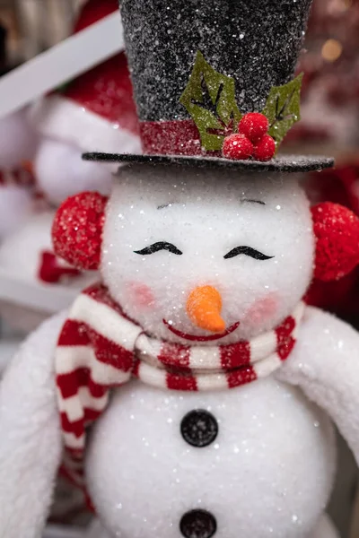 Smiling Christmas snowman. Happy snowman wearing black hat and scarf. Christmas and New year concept. Nobody, selective focus