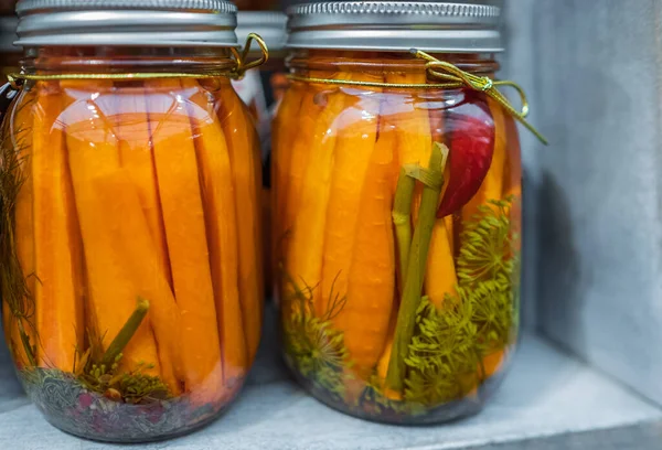Healthy fermented food. Homemade fermented carrots with garlic, dill and pepper in a glass jar. Homemade marinated carrots pickles. Nobody, selective focus
