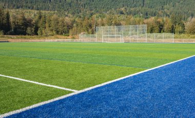 Futbol sahası. Beyaz çizgili yeşil sentetik çimen spor sahasının fotoğrafı. Hiç kimse, seçici odak, sokak fotoğrafı.