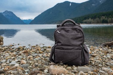 Sırt çantası dağda ve gölde. Kanada 'daki dağda sırt çantasıyla manzara. Hiç kimse, seyahat fotoğrafı, seçici odak