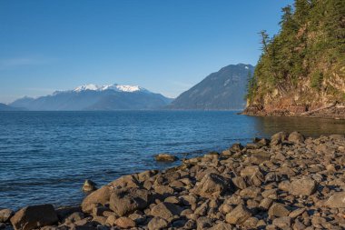 Harrison Gölü ve dağları M.Ö. Sudaki nehir taşı, yaz doğası. Su ve taşlar. Kıyılarda büyük taşlar. Seyahat fotoğrafı, kimse yok.