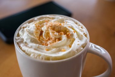 Masanın üzerinde sütlü kahve bardağı var. Kahvaltıda sabah kahvesi. Hiç kimse, bulanık, seçici odaklanma