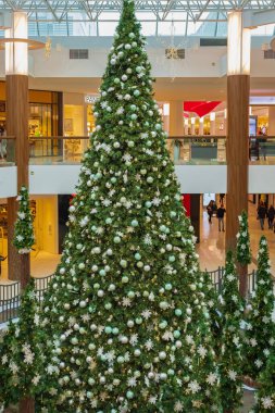 Alışveriş merkezindeki büyük noel ağacı. Guildford Surrey Kanada 'daki alışveriş merkezinde renkli çelenkler ve toplarla süslenmiş büyük parlak Noel ağacı 7 Aralık 2022