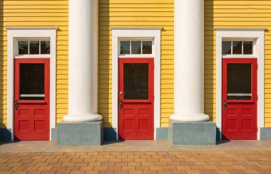 Kırmızı kapılar. Sütunları olan eski tarihi bir evin girişinde üç renkli ön kapı. Seyahat fotoğrafı, hiç kimse, sokak fotoğrafı.