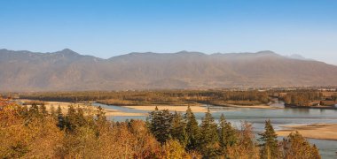 Güneşli sonbahar manzarası. Nehir ve dağlarla vadide sabah güneşi. Britanya Kolombiya Kanada 'sında günbatımında sonbahar sahnesi. Seyahat fotoğrafı, kimse yok.